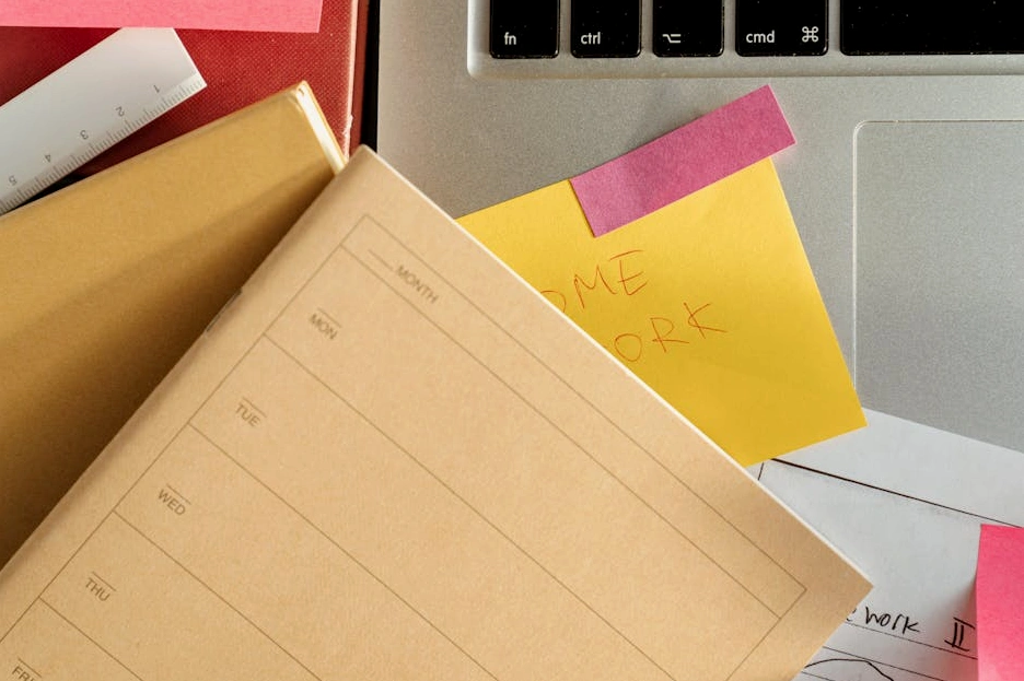 Una persona che prende appunti mentre studia al computer.